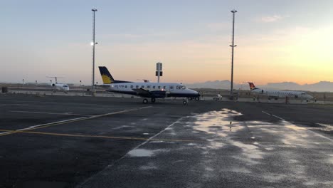 VIP-Lear-Jets-In-Parkposition-Am-Internationalen-Flughafen-Von-Kapstadt,-Privater-Executive-Jet-Flugplatz-Mit-Goldenem-Sonnenuntergang-über-Der-Silhouette-Des-Tafelbergs-Und-Nassem-Asphalt