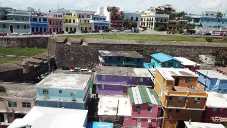 San-Juan,-Puerto-Rico,-Pull-Back-Aerial-Revealing-View-on-Vibrant-La-Perla-District-on-Atlantic-Ocean-Coast