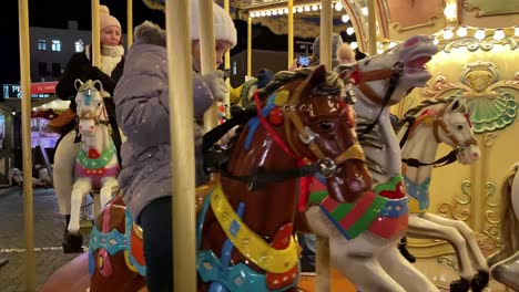 Close-up-horses-on-christmas-corousel,-children-hava-a-lot-funbefore-christmas