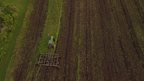 Tractor-Agrícola-Labrando-Un-Vasto-Campo-En-El-Condado-De-Monroe,-Michigan---Antena