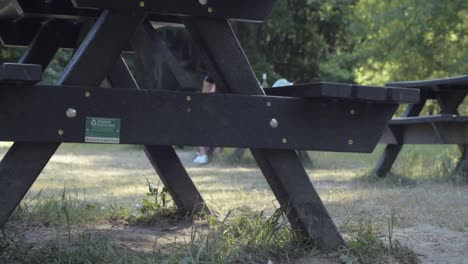 Wooden-picnic-tables-in-park-land-panning-shot