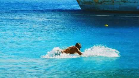 Aktiver-Mann,-Der-Auf-Einem-Seabob-Reitet-Und-Auf-Der-Oberfläche-Des-Blauen-Ozeans-In-Willemstad,-Curaçao,-Durchbricht