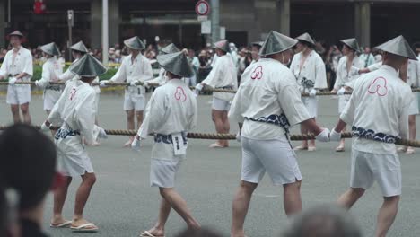 Hombres-Japoneses-Preparándose-Para-Tirar-De-La-Cuerda-Del-Flotador-Hoko-Durante-Las-Procesiones-Yamaboko-Junko-Del-Desfile-De-Carrozas-Del-Festival-Gion-Matsuri-En-Kyoto,-Japón