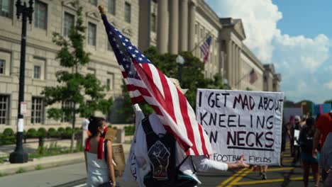 A-white-military-veteran-carries-a-sign-about-kneeling-on-football-fields-versus-kneeling-on-necks-in-the-Washingon-DC-protests