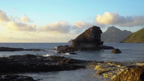 The-rocky-shoreline-by-the-mountain-islands-of-Fiji-during-sunset---wide-shot