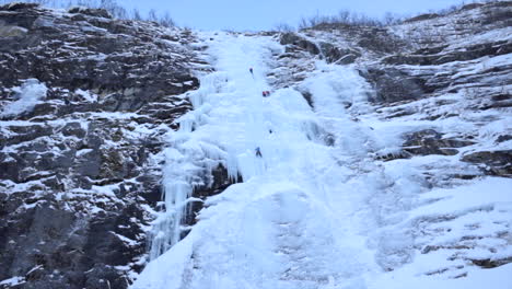 A-Team-of-Ice-Climbers-Scaling-an-Impressive-Ice-Wall,-Wide