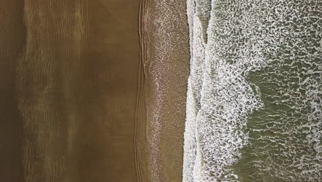 Aerial-View-Of-The-Waves-Washing-Up-On-The-Beach-Shore-Of-Saunton-Sands-At-North-Devon,-England,-United-Kingdom