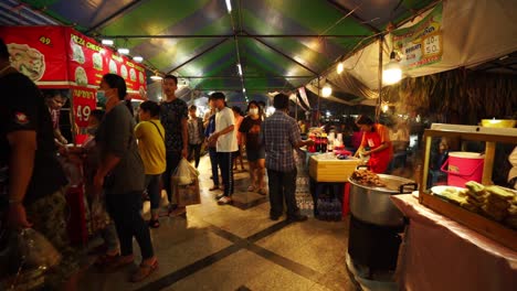 Slow-motion-push-in-shot-of-thai-market-with-people-passing-by