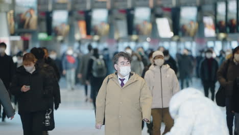 Personas-Con-Máscara-Médica-En-La-Estación-De-Tren-De-Shinagawa-Debido-A-Una-Nueva-Cepa-De-Covid-19-En-Tokio,-Japón