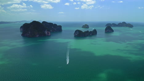 aerial-panorama-view-of-thai-island-formation,-longtail-boat-sailing
