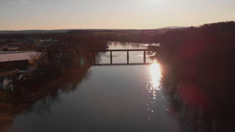 Railroad-bridge-spanning-Susquehanna-river-in-silhouette,-Aerial,-Slow-Motion