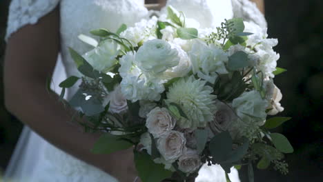 Schöne-Braut-Lächelt-Und-Hält-Einen-Blumenstrauß-Am-Hochzeitstag-Im-Freien