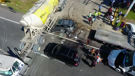Aerial-view-of-a-traffic-accident,-damaged-passenger-car-crushed-under-a-oil-truck,-in-Puerto-Rico,-USA---tracking,-drone-shot