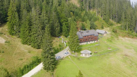 Wide-establish-aerial-drone-shot-of-an-empty-farm-with-wooden-mansion-in-forest