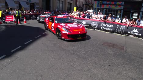Racing-cars-driving-on-road-surrounded-by-fans-during-Gumball-3000-Event-in-London
