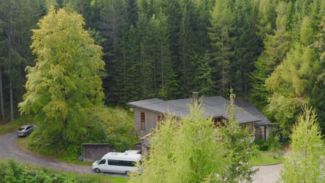 Drone-shot-of-a-cabin-surrounded-by-forest