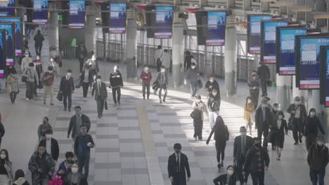 Menschenmenge-Mit-Masken,-Die-An-Einem-Geschäftigen-Morgen-In-Tokio-Am-Bahnhof-Shinagawa-Spazieren-–-Hoher-Winkel,-Zeitlupe