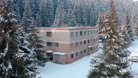 Verfallenes-Gebäude,-Umgeben-Von-Verschneiten-Kiefern-Im-Winterwald-–-Weitwinkelaufnahme
