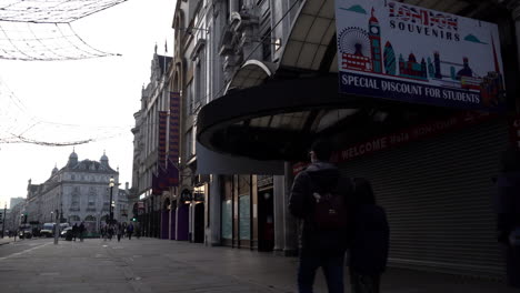 A-slow-motion-shot-of-people-walking-past-closed-shutters-on-shops-and-businesses-on-Coventry-street-near-Piccadilly-Circus-during-the-second-national-lockdown-due-to-the-Covid-pandemic