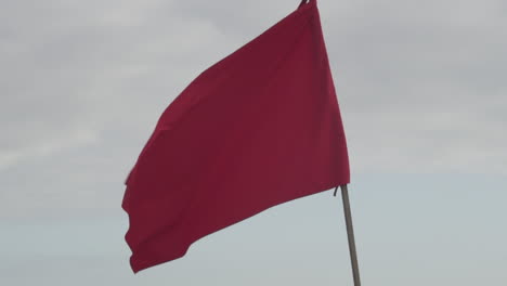 Rote-Fahne-Weht-Am-Klaren-Himmel---Warnung-Vor-Gefahr---Nahaufnahme