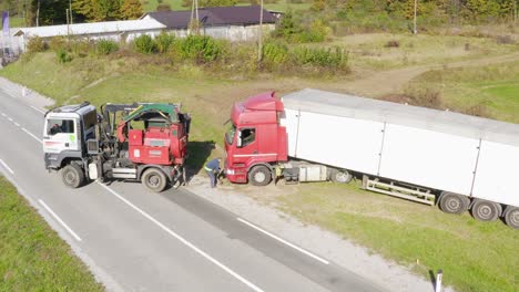 Fahrer-Befestigt-Seil-Des-Zugfahrzeugs-Am-Sattelschlepper-Am-Straßenrand