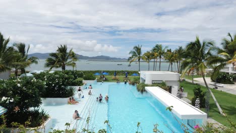 tourists-enjoying-holiday-in-outdoor-pool-in-casino-hotel-in-the-ville-resort-casino-in-townsville,-North-Queensland