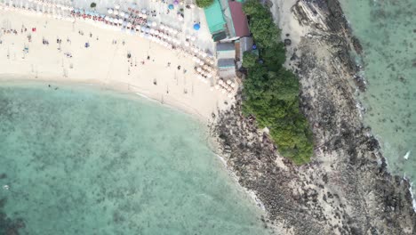 Draufsicht-Auf-Den-Tropischen-Strand-Mit-Menschen,-Die-Unter-Sonnenschirmen-In-Thailand-Schwimmen-Und-Entspannen