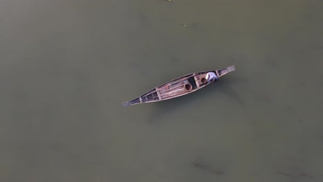 Small-traditional-wooden-boat-with-fisherman,-Aerial-top-down