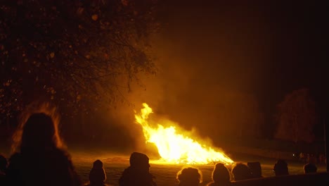 Silhouette-shot-of-a-large-crowd-watching-a-large-bonfire-on-Guy-Fawkes-Night