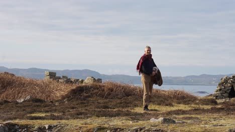 Zeitlupenschwenk-Eines-älteren-Mannes,-Der-Mit-Einem-Tartan-Schal-Am-Meer-In-Schottland-Steht