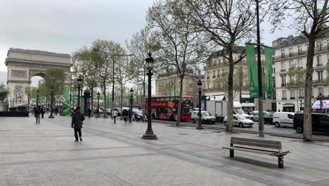 Peatones-Caminando-Por-Los-Campos-Elíseos-Frente-Al-Arco-Del-Triunfo,-Uno-De-Los-Principales-Lugares-De-Interés-De-París,-Francia