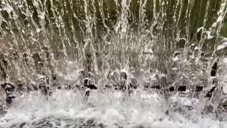 View-behind-waterfall,-water-crashing-into-stream-below,-slow-motion