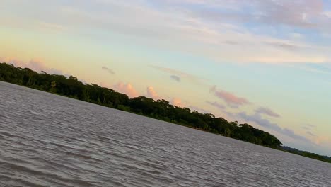 Rotating-slow-motion-shot-of-the-sun-setting-over-a-river-and-forest-in-Sylhet