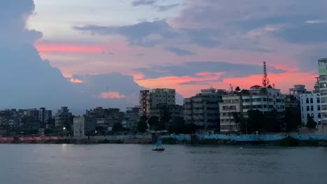 Dolly-Aufnahme-Entlang-Des-Buriganga-Flusses-In-Der-Innenstadt-Von-Dhaka-Mit-Einem-Lebendigen-Sonnenuntergang