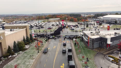 Drone-aerial-shot-of-funeral-to-murdered-canadian-police-officers-by-thousands-of-joint-military-officers-at-the-Sadlon-Arena-in-Barrie,-Ontario,-Canada