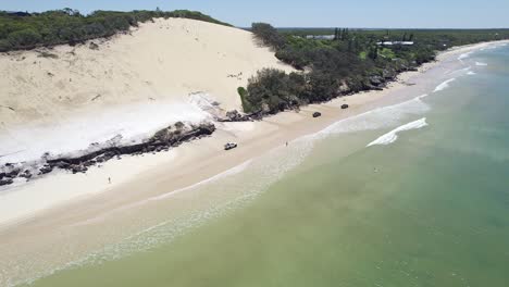 Cars-Driving-On-The-Beach-By-The-Carlo-Sandblow-In-Rainbow-Beach,-Cooloola,-Queensland,-Australia