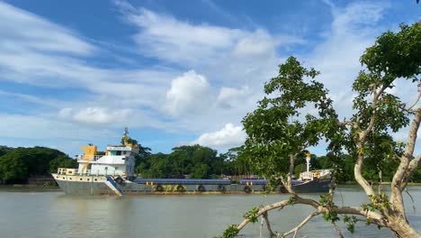 Tracking-shot-of-a-small-cargo-barge-sailing-through-river-in-Sylhet