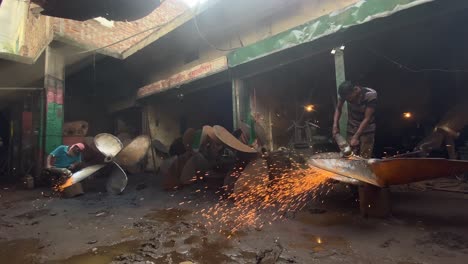 Handaufnahme-Von-Männern,-Die-In-Einer-Werkstatt-In-Dhaka-Schiffspropeller-Abschleifen