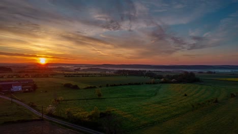 Luftaufnahme-Des-Sonnenuntergangs-über-Einem-Großen-Bauernhaus-In-Der-Ländlichen-Landschaft