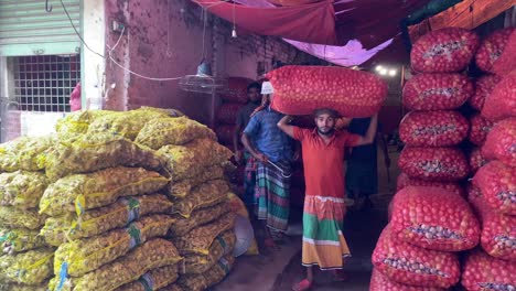 Trabajadores-Descargando-Grandes-Sacos-De-Jengibre,-Cebollas-Del-Almacén,-Dhaka,-Bangladesh