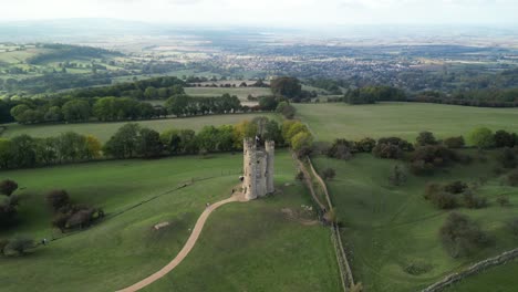 Dramática-Toma-Aérea-Amplia-Empujando-Hacia-La-Torre-De-Broadway,-Un-Hito-Inglés-Se-Encontraba-En-Lo-Alto-De-Beacon-Hill-En-Los-Cotswolds,-Reino-Unido