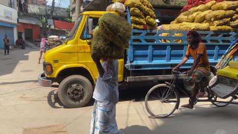 Hombre-Cargando-Bolsas-De-Jengibre-En-La-Cabeza-A-Lo-Largo-De-La-Calle,-Bangladesh