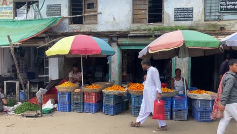 The-bustling-bazaar-market-of-a-third-world-country-is-a-hub-of-commerce,-with-vendors-and-customers-alike-braving-the-street-and-seeking-shelter-from-the-sun-under-umbrellas