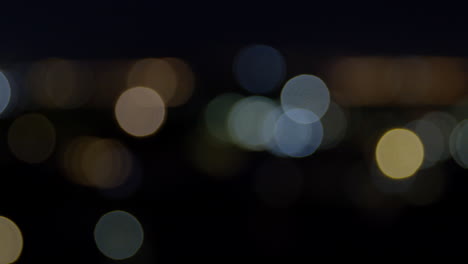 Beautifully-illuminated-Bokeh-lights-at-nighttime-in-Wellington,-slow-pan-left