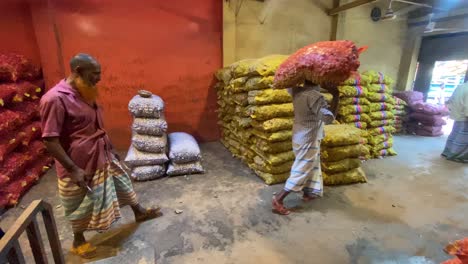 Tracking-shot-of-employees-carrying-the-packed-produce-out-of-the-warehouse-in-Bangladesh