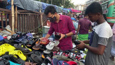 People-shopping-at-a-busy-shoe-store-in-India-with-a-van-cart-and-customers
