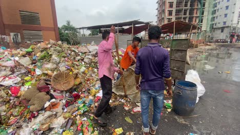 Personas-Trabajadoras-Que-Apilan-Basura-Y-Desechos-En-Una-Pila,-Mostrando-El-Importante-Papel-De-La-Gestión-De-Desechos-En-Países-Del-Tercer-Mundo,-Como-El-Medio-Oriente-O-Asia