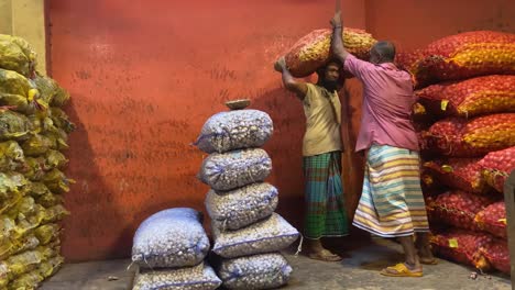 Tracking-shot-of-a-man-lifting-bags-of-spices-in-a-shop-and-carrying-them-away