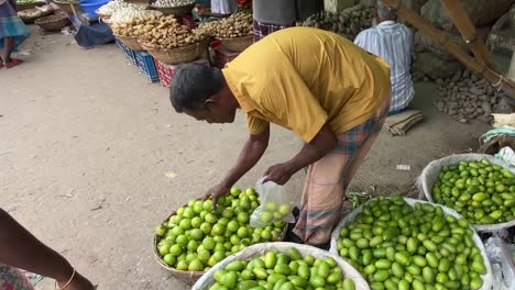 Toma-En-Cámara-Lenta-De-Un-Vendedor-Ambulante-Embolsando-Limones-Frescos-Para-Un-Cliente-En-Dhaka