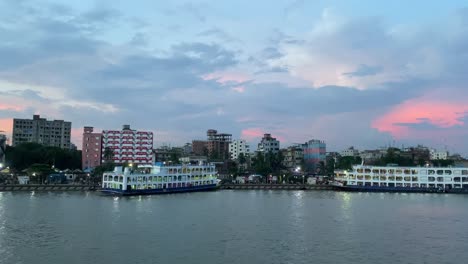 Aerial-panning-shot-along-the-docked-ships-at-the-terminal-at-Sadarghat,-Dhaka-City,-Bangladesh